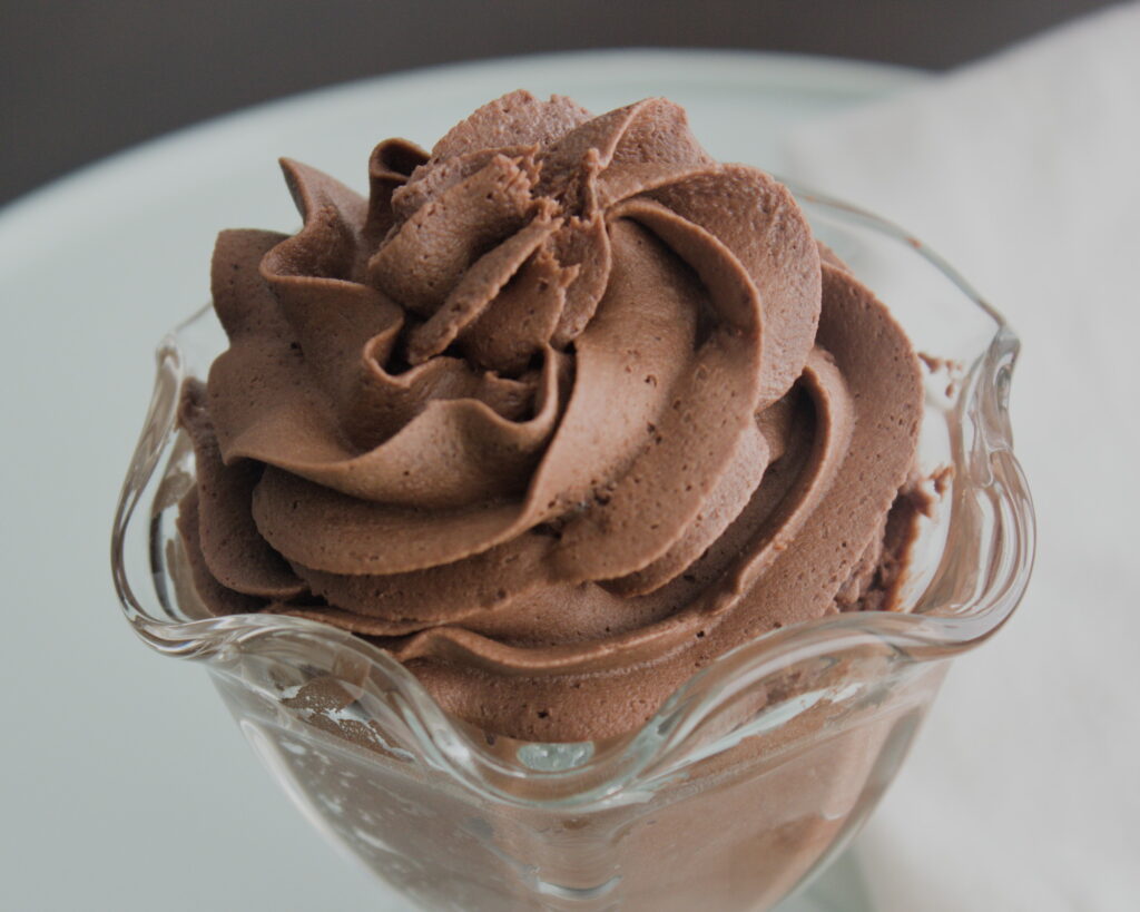 Dairy free chocolate frosting without butter piped into a glass dessert dish