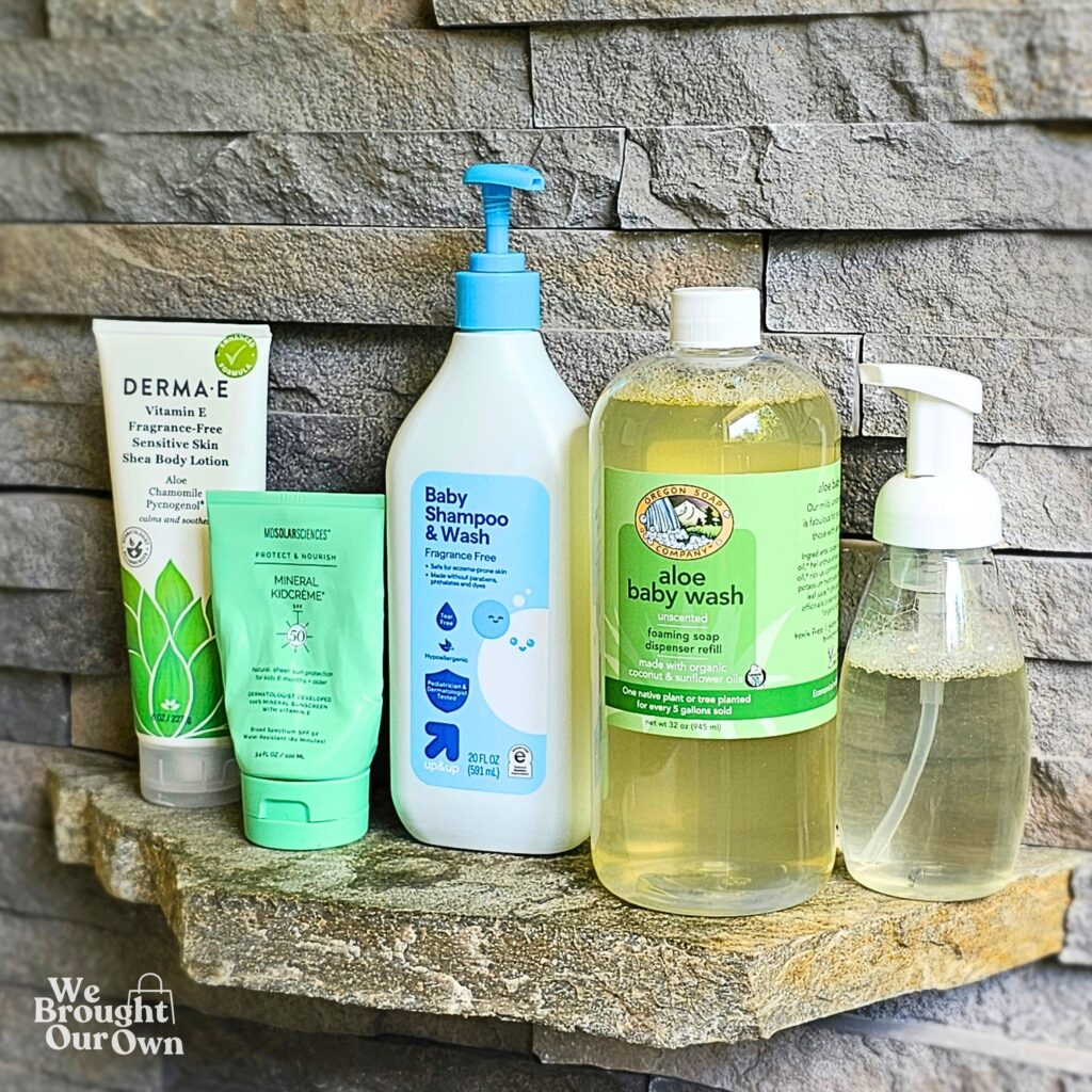 Derma E body lotion, MD Solar Sciences mineral sunscreen, Target Up&Up fragrance free baby wash, and Oregon Soap Company aloe baby wash lined up on a stone shelf