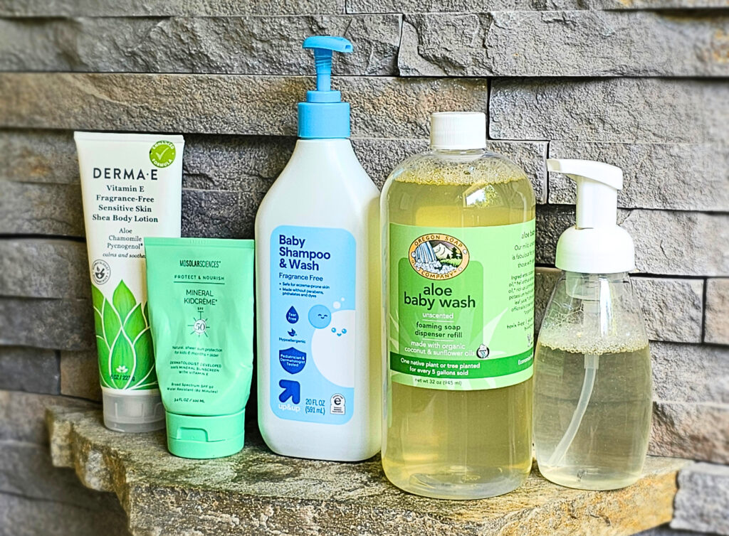Derma E body lotion, MD Solar Sciences mineral sunscreen, Target Up&Up fragrance free baby wash, and Oregon Soap Company aloe baby wash lined up on a stone shelf